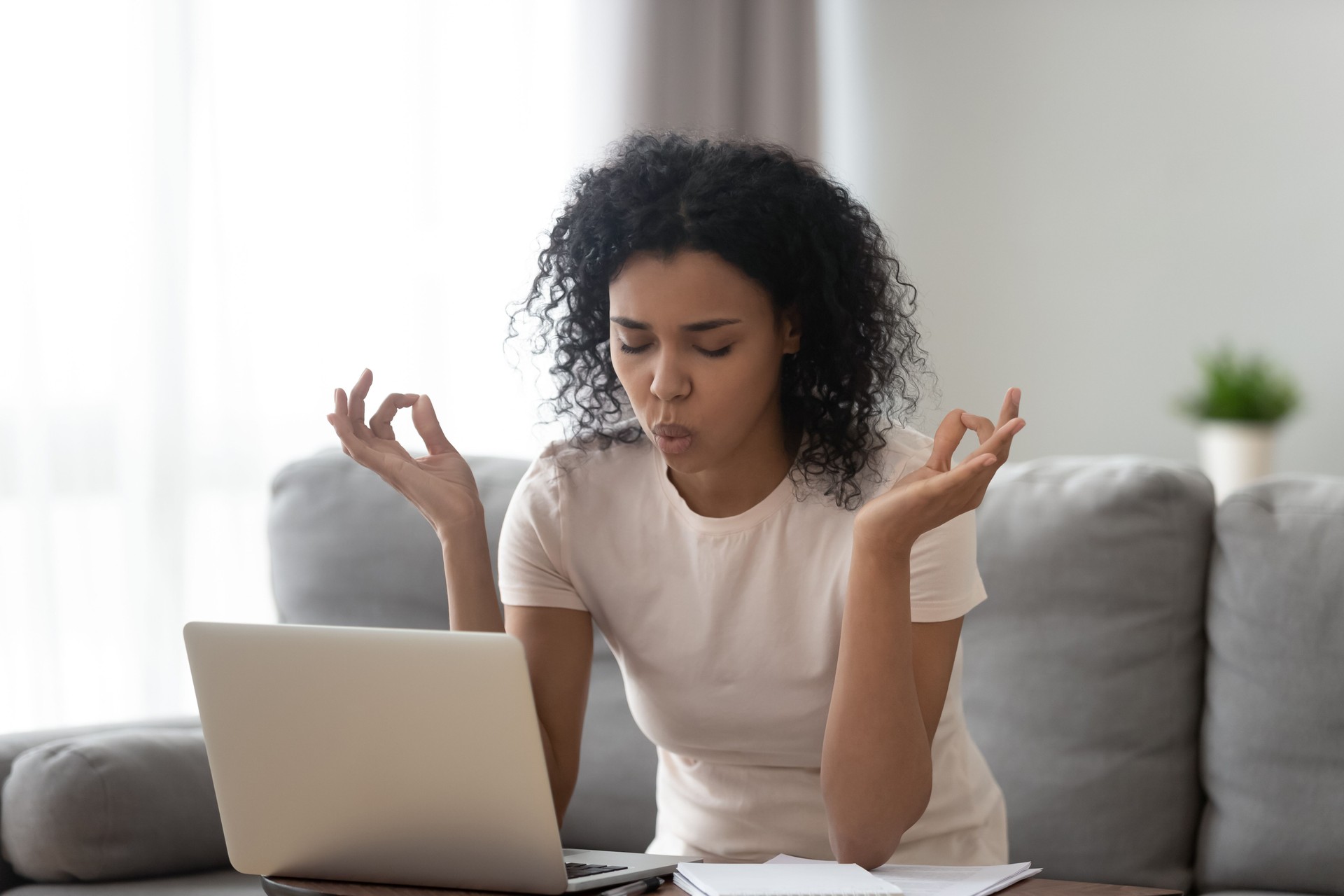 African woman reducing stress do yoga exercise to calm down