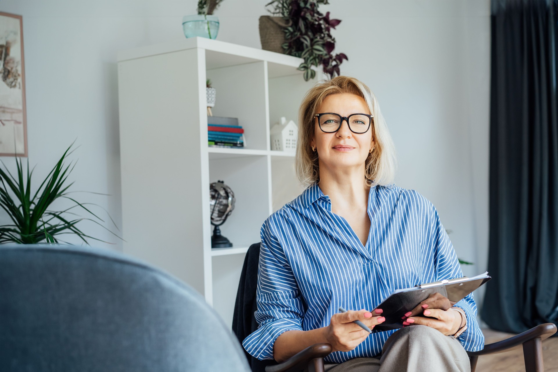 Professional Psychotherapy. Successful female Psychologist Smiling To Camera Sitting On armchair In Office. Mature 50s middle-aged professional portrait teacher, coach, mentor, therapist, counselor